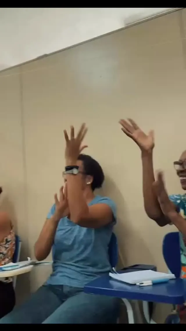 Alunos adultos praticando sinais em Libras durante a aula no Integrando