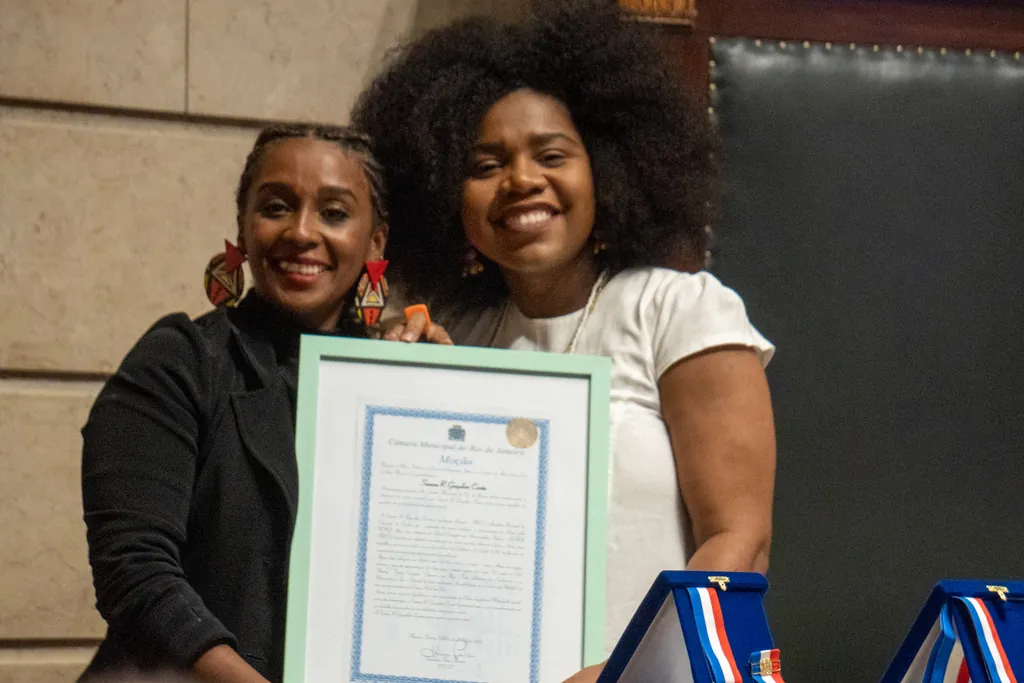 Suanne Gonçalves recebendo a Moção de Louvor e Aplausos da Câmara Municipal do Rio, das mãos da vereadora Thaís Ferreira