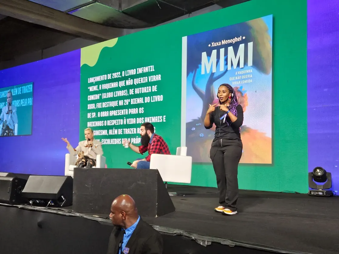 Suanne Gonçalves interpretando em Libras em palco de evento literário